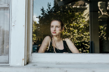 Girl looking out the window of her LA home during the covid-19 pandemic