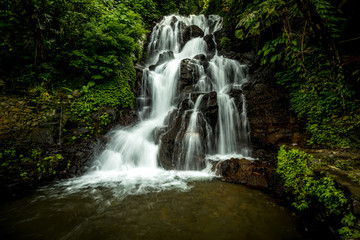 Fototapeta na wymiar Waterfall landscape. Beautiful hidden Jembong waterfall in tropical rainforest in Ambengan, Bali. Slow shutter speed, motion photography.
