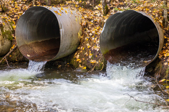 Old aging infrastructure. Three perched old and rusty culverts creating a barrier to fish in a stream on a forest road.