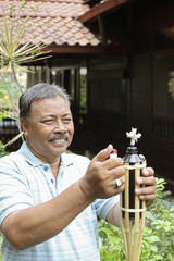 Senior man lighting bamboo torch