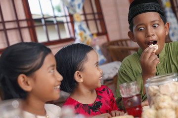 Children enjoying traditional cookies, boy making funny face