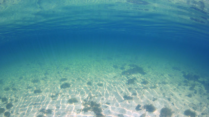 Fototapeta na wymiar Sea sand and blue water underwater photo 