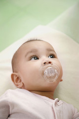 Baby sucking on pacifier while looking up