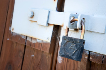old padlock hanging on an old fence closeup