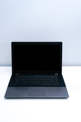 A dark gray laptop on a white desk.