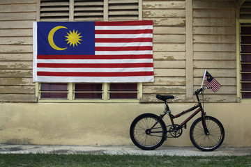 Bicycle with small flag outside Malay house