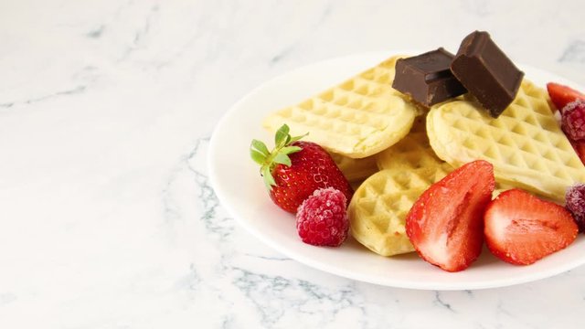 Delicious decorated waffles with strawberries, raspberries and chocolate 