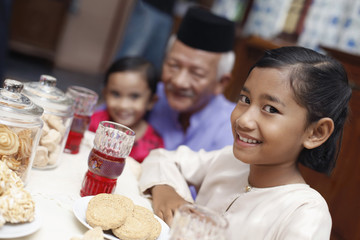 Senior man enjoying traditional cookies with his grandchildren
