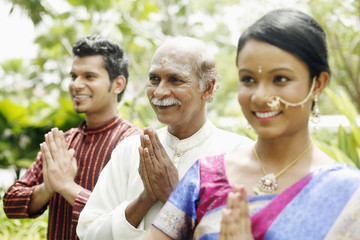 Couple and senior man praying
