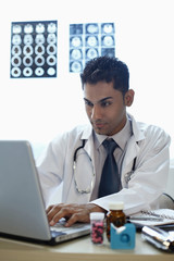 Fototapeta na wymiar Doctor using laptop at his desk