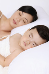 Fototapeta na wymiar Woman sleeping beside baby girl