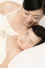 Obraz na płótnie Canvas Woman watching baby girl sleep