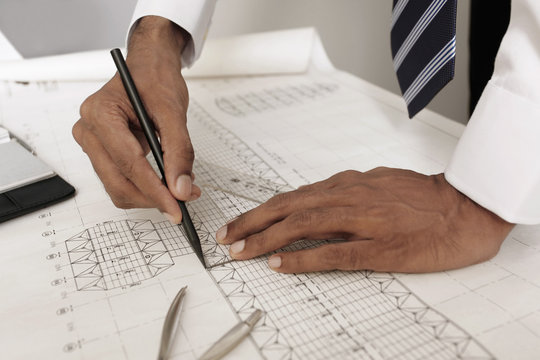 Architect drawing on blueprint - Powered by Adobe