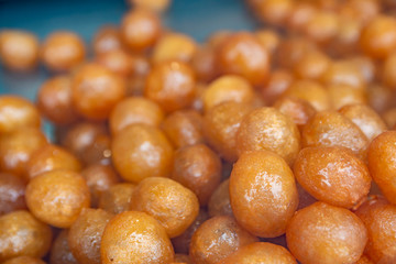 Tulumba tatlisi, is a kind of traditional Turkish sweet. Ball shaped dough's fried in oil and then added into a kind of sugar water syrup. Food background and close up