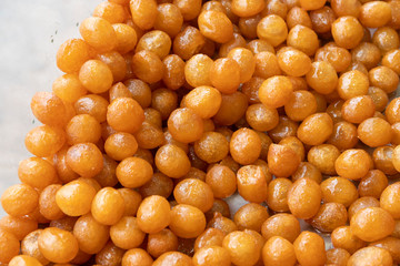 Top view on many gold brown fried Tulumba tatlisi. A traditional Turkish sweet. Ball shaped dough's fried in oil and then added into a kind of sugar water syrup. Food background