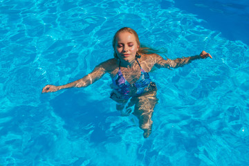 Fashion portrait of beautiful sexy young woman in swimming pool