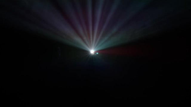 Bright color beam of video projector against dark background