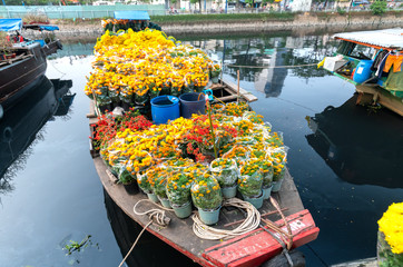 Flower boats full of flowers parked along canal wharf, a place for bustling flower market trade lunar new year in Ho Chi Minh City, Vietnam © huythoai