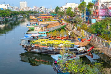 Flower boats full of flowers parked along canal wharf, a place for bustling flower market trade...