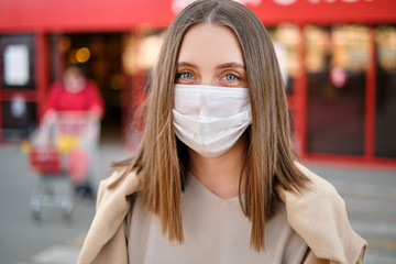 Close-up Woman portret in a protective mask during a coronovirus pandemic stands opposite the...