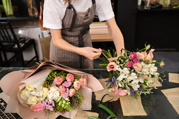 Gardener's in the flower shop make bouquet for a holiday. Family flower's business. Lifestyle flower shop. Beautiful flower composition. Detail. Close up.