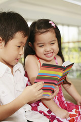 Boy and girl reading book together