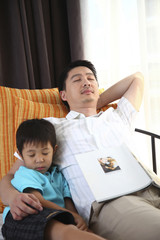 Man and boy taking a nap in the room
