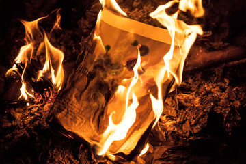 Camp fire flames wooden combustible. paper burning heat and embers black background wit copy space
