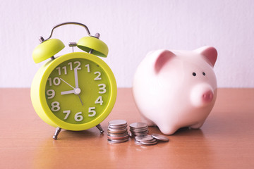 Piggy bank, alarm clock and coins. for growing business. time to saving concept.