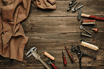Flat lay composition with leather samples and set crafting DIY tools on wooden table background...