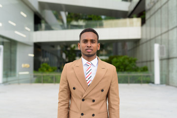 Fototapeta premium Young handsome African businessman wearing suit in the city outdoors