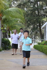 Fototapeta na wymiar Men and boy taking a stroll down the promenade