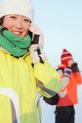Women in warm clothing talking on mobile phone