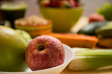 red apple with mango in the foreground with fruit in the background. healthy food concept
