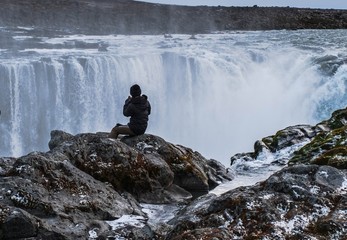 A tourist looking at the Selfoss jump on the edge of the gorge