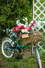 Fototapeta na wymiar Beautiful bicycle with flowers in a basket stands on an avenue