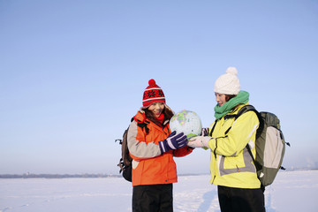 Women examining globe together