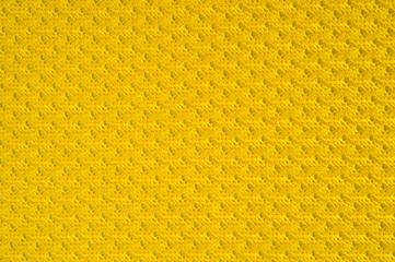 Synthetic yellow perforated stretch fabric, photographed close-up.
