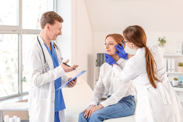 Fototapeta na wymiar Plastic surgeons examining woman in clinic