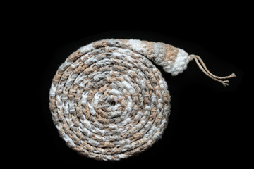 Crochet tape melange yarn brown and beige color on a black background close-up. Top view. Hand-made concept