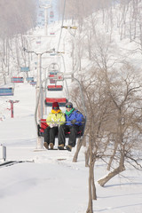 Man and woman traveling on ski lift