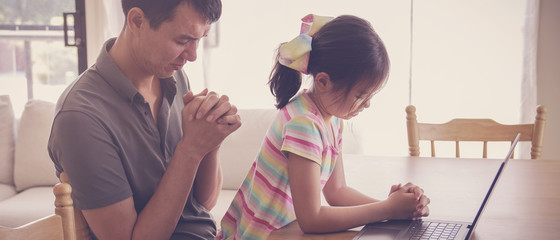 Young girl praying with father parent with laptop, family and kids worship online together at home,...