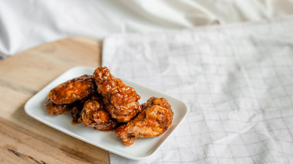 fried chicken wings with spicy sauce on cutting board