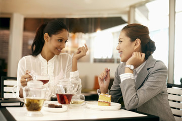 Businesswomen enjoying tea and cake at a cafe