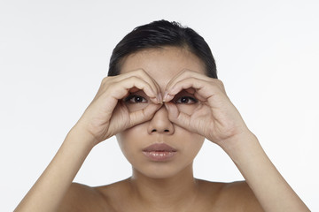 Woman looking through her hands as binoculars