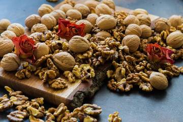 Shelled and shelled walnuts on a wooden board on the table. Healthy nutrition, vegetarianism, diet.