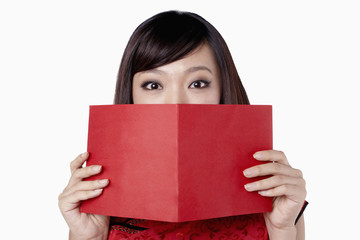 Woman in traditional clothing covering her mouth with a greeting card