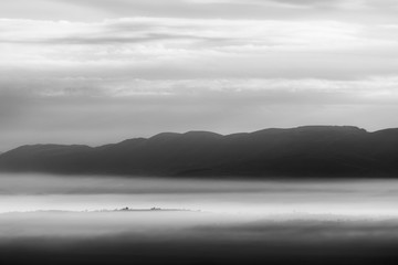 Fototapeta na wymiar Fog filling a valley in Umbria (Italy), with layers of mountains and hills
