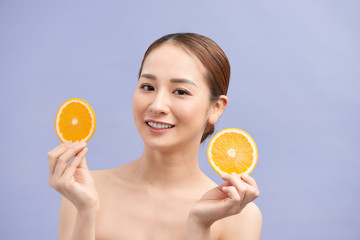 beautiful young asian woman with long hair, flawless skin and perfect make-up. Holding orange