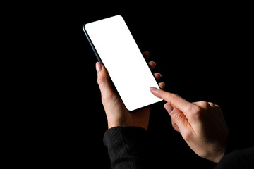 Person holding in hands and using mobile phone with empty white screen, photo isolated on black background